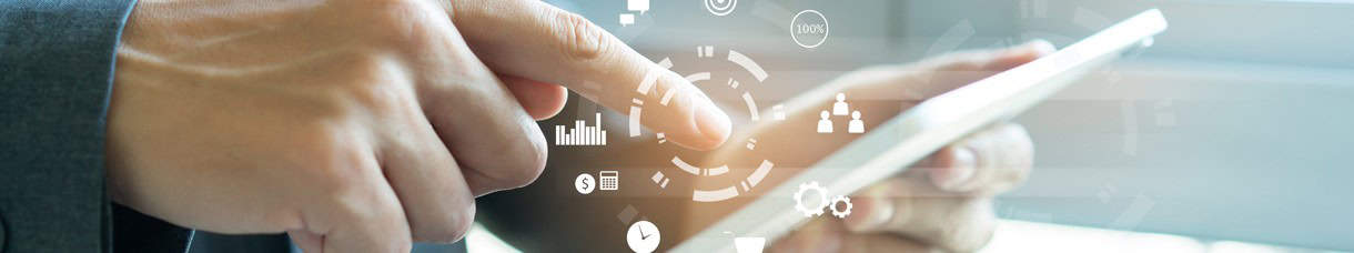Eine Person bedient ein Tablet mit digitalen Geschäfts- und Finanzsymbolen im Vordergrund.
